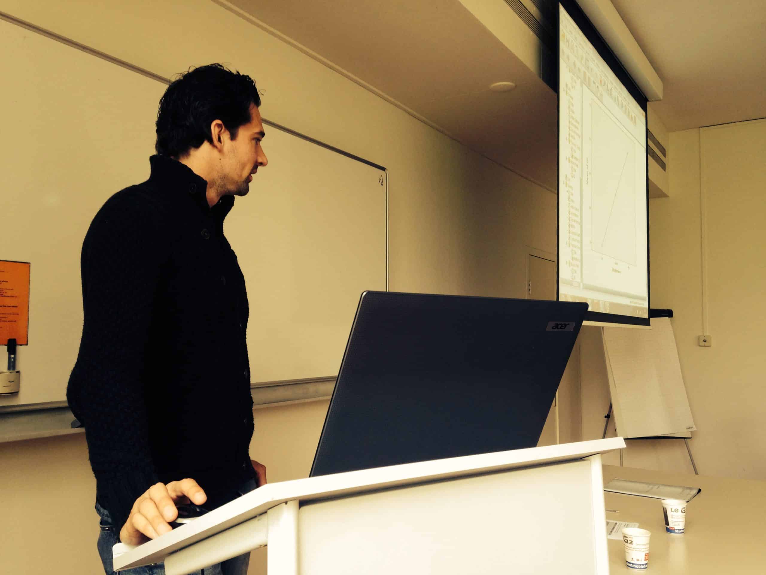 Fabian Tania aan het katheder tijdens een statistiektraining met SPSS op het projectiescherm